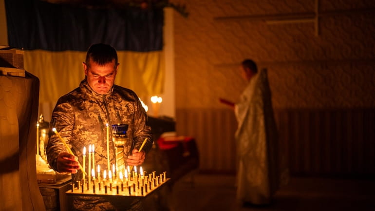 An Ukrainian serviceman of the 72nd Separate Mechanized Brigade, lights...