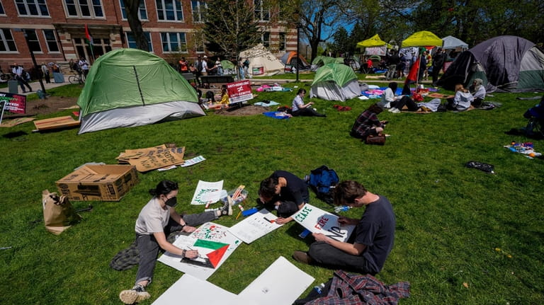 Protesters make signs in an encampment area on the University...