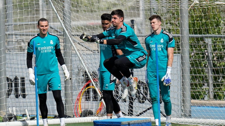 Real Madrid's goalkeeper Thibaut Courtois, 3rd left trains watched by...