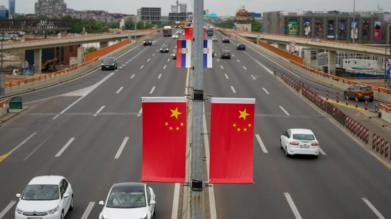 Chinese and Serbian flags fly on lampposts, days before the...