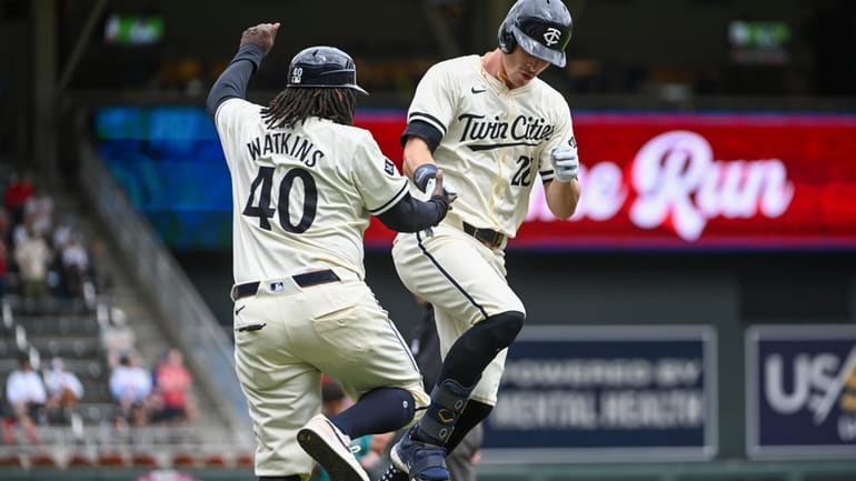 Minnesota Twins' Max Kepler, right, celebrates with third base coach...