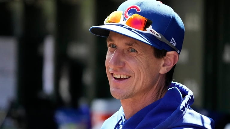 Chicago Cubs manager Craig Counsell smiles as he watches players...