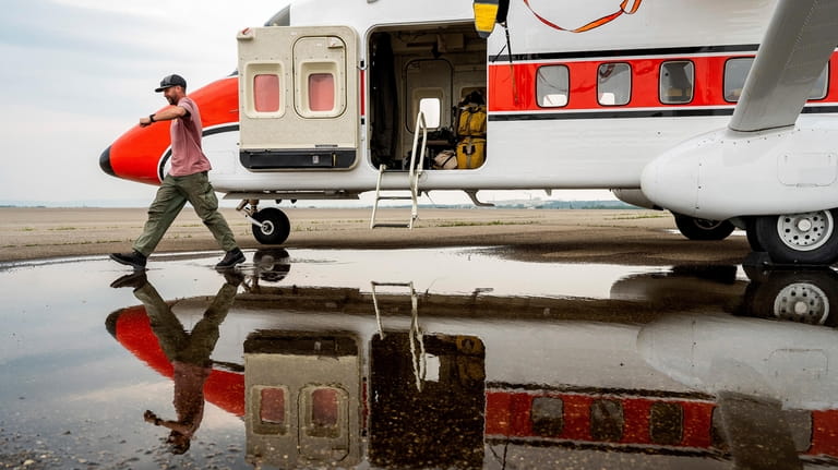 U.S. Forest Service smokejumper Mike Dunn steps through a puddle...
