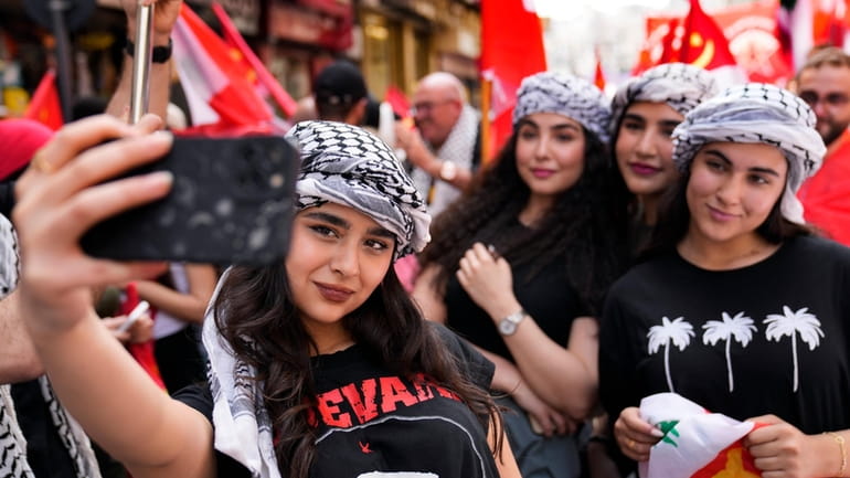 Supporters of the Lebanese Communist party, take selfie, as they...