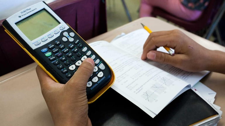 A student at Center Moriches High School uses a calculator...