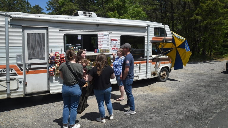 People enjoy hot dogs at a truck on Middle Country Road...