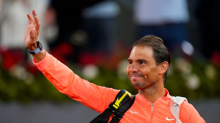 Rafael Nadal, of Spain, waves to the crowd after losing...