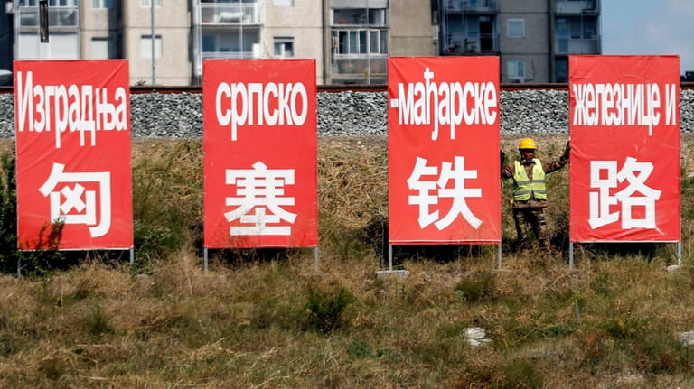 A worker rests between billboards that read: ''Construction of the...