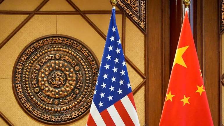 Flags of the U.S and China sit in a room...