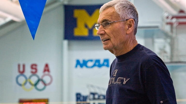 Retired University of Michigan coach Jon Urbanchek watches over the...