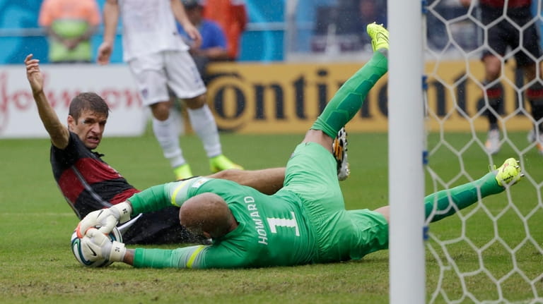 United States' goalkeeper Tim Howard dives to make a save...