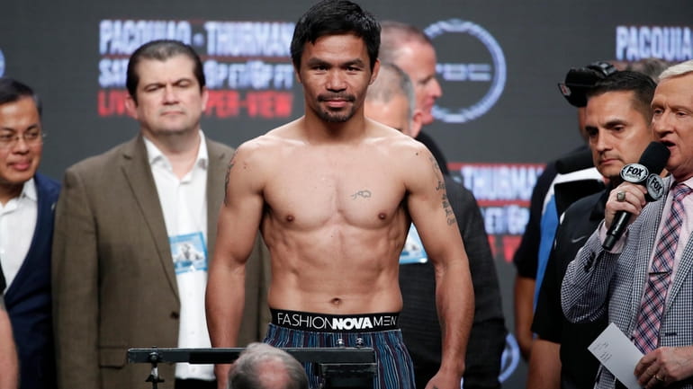 Manny Pacquiao stands on the scale during a weigh-in Friday,...