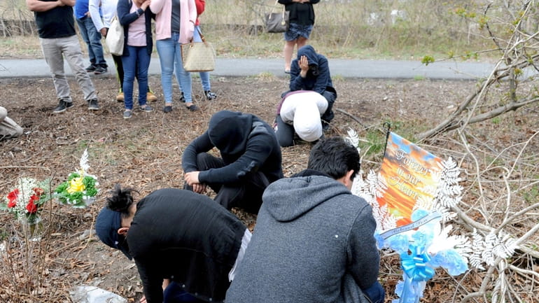 Family members of four young men cry at the spot...