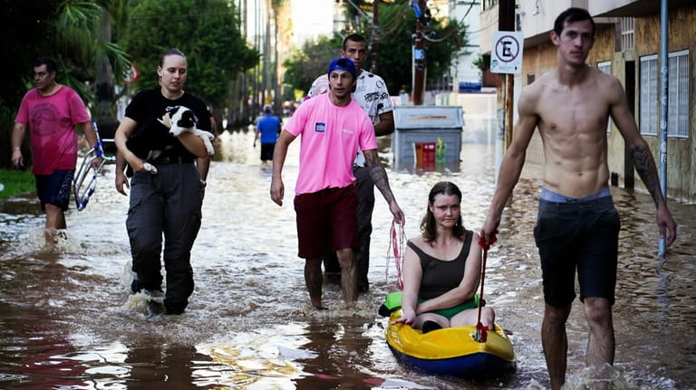 A woman is rescued from an area flooded by heavy...