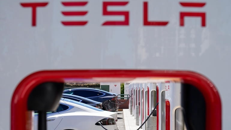 Tesla vehicles charge at a station in Emeryville, Calif., Aug....
