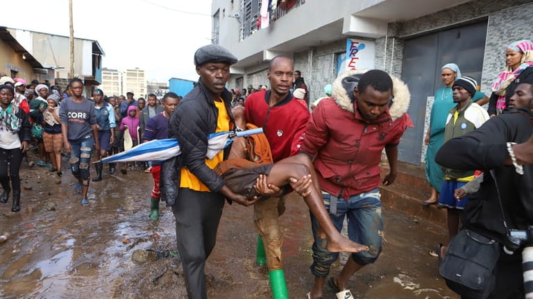 Residents rescue a woman who was caught during heavy rain...