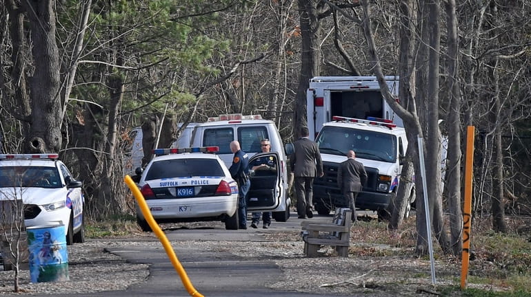 Suffolk County Police investigate the crime scene where four bodies...