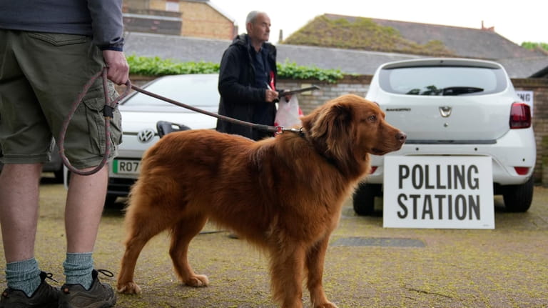 A voter waits with his dog outside a polling station...