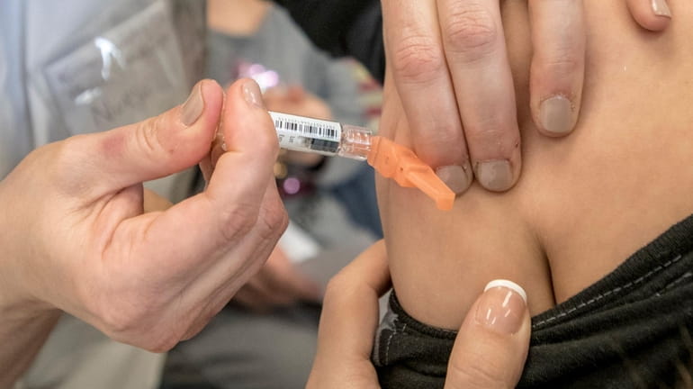 A boy gets a flu shot at the Nassau County Department of Health...