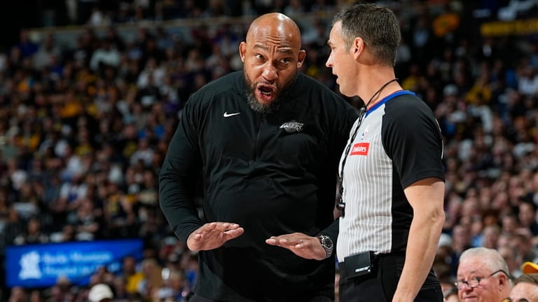 Los Angeles Lakers head coach Darvin Ham, left, argues for...