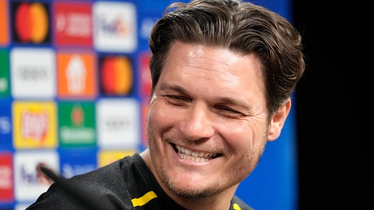 Dortmund's head coach Edin Terzic smiles at a press conference...