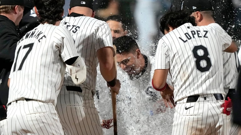 Chicago White Sox's Andrew Benintendi, center, celebrates with teammates after...
