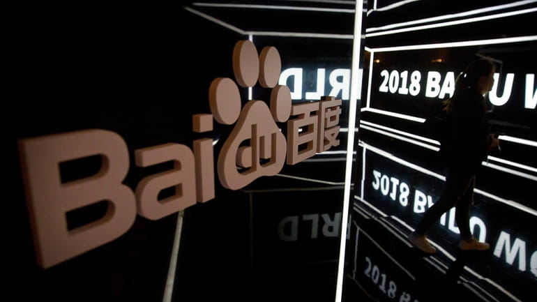 An attendee walks past a display at the Baidu World...