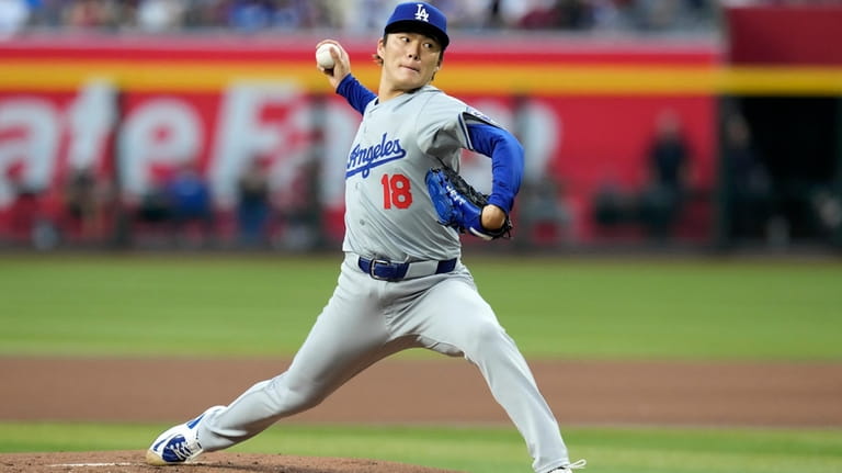 Los Angeles Dodgers starting pitcher Yoshinobu Yamamoto, of Japan, throws...