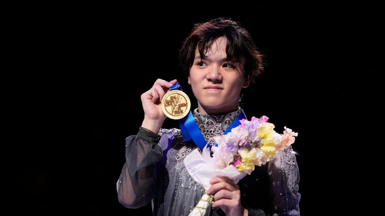 Shoma Uno of Japan shows off his gold medal after...