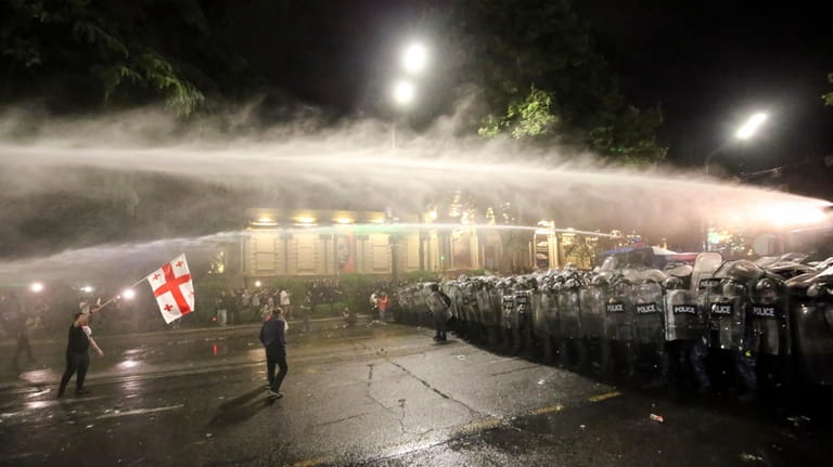 Riot police use a water cannon during an opposition protest...