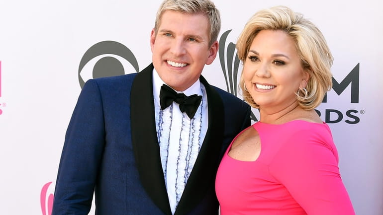 Todd Chrisley, left, and his wife, Julie Chrisley, pose for...