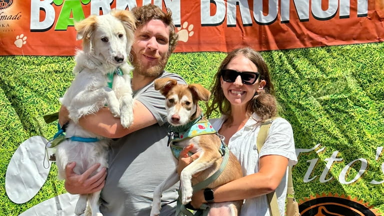 People pose with their dogs while attending "Barkin' Brunch," a...