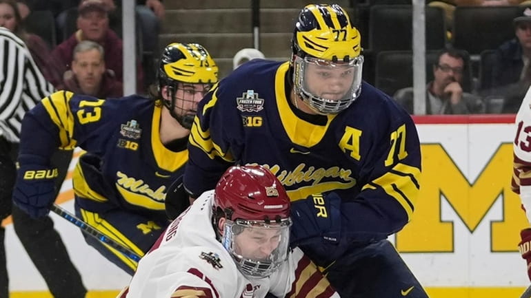 Boston College forward Jamie Armstrong, front left, and Michigan defenseman...