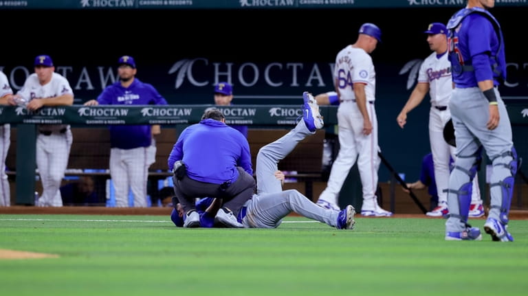 Chicago Cubs starting pitcher Justin Steele lies on the ground,...