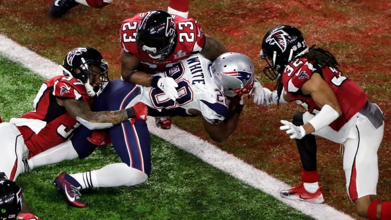 The Patriots' James White scores the winning touchdown during overtime...