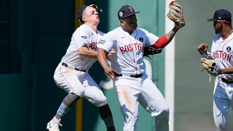 Boston Red Sox's Rafael Devers, center, collides with teammate Tyler...
