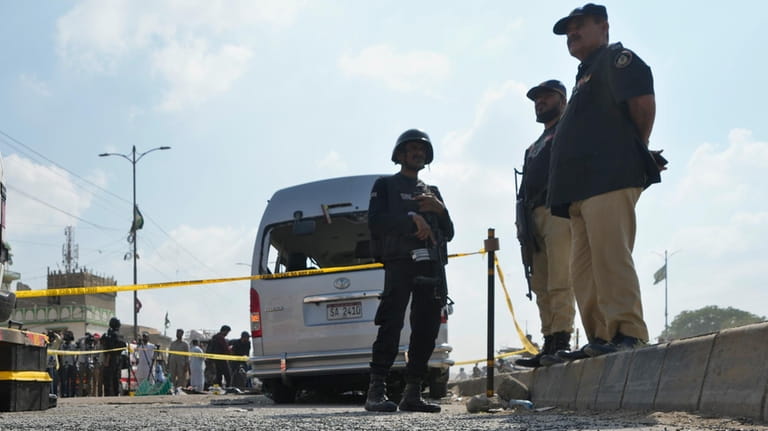 Police officers stand guard at the site of suicide attack...