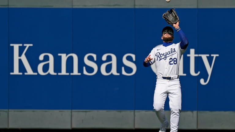 Kansas City Royals center fielder Kyle Isbel catches a fly...