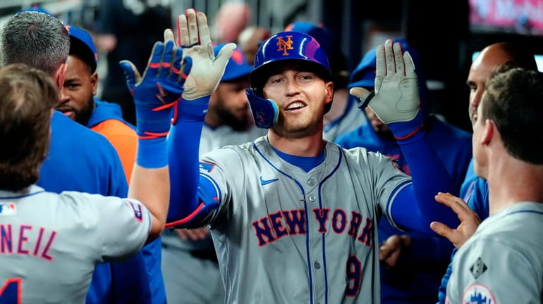 The Mets' Brandon Nimmo celebrates in the dugout after hitting...