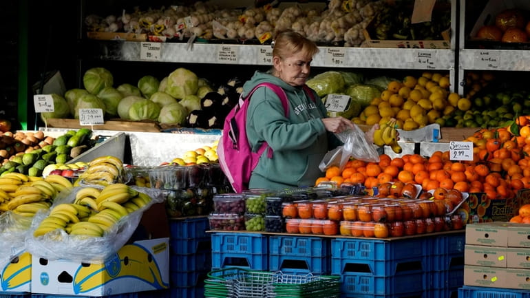 A woman selects fruits at a supermarket in London, on...
