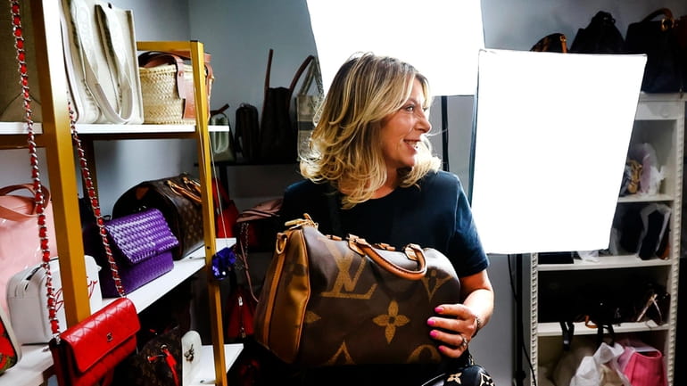 Deborah Mayer holds one of the luxury handbags she sells...