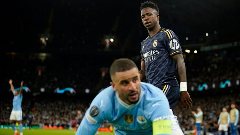 Manchester City's Kyle Walker falls next to Real Madrid's Vinicius...