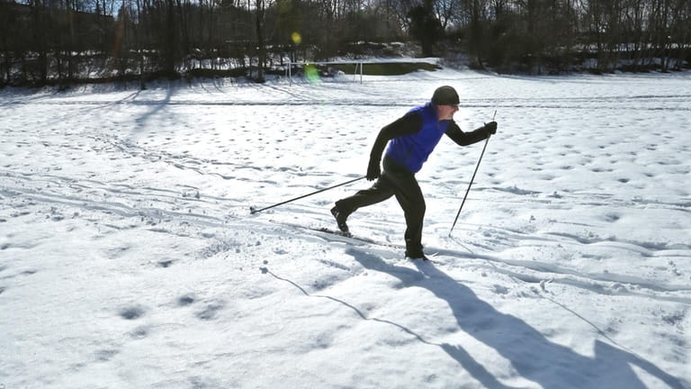 John Sohl of Kings Park skis across a field at...