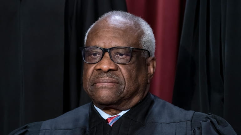 Associate Justice Clarence Thomas joins other members of the Supreme...