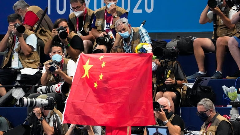A Chinese flag is unfurled on the podium of a...