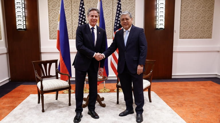 U.S. Secretary of State Antony Blinken, left, shakes hands with...