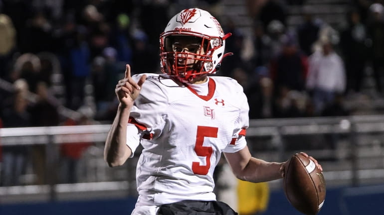 East Islip quarterback Thomas Costarelli rolls out to pass during...