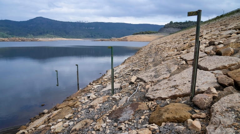 Water level markers stand in the San Rafael reservoir, a...