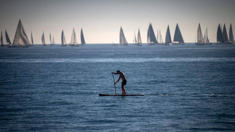 A man paddles in the Mediterranean Sea in Barcelona, Spain,...
