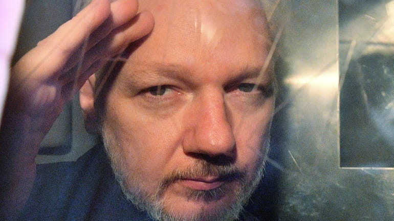 WikiLeaks founder Julian Assange looks out of a prison van...